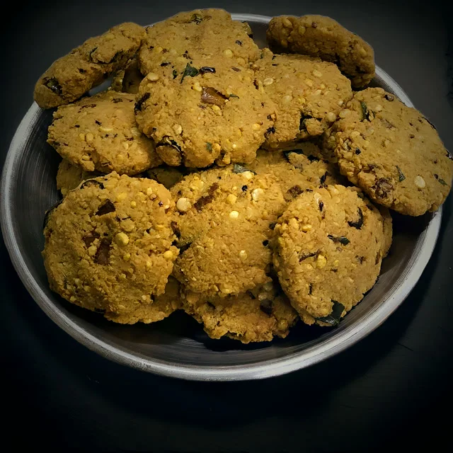 Masala vadai stacked on a steel plate