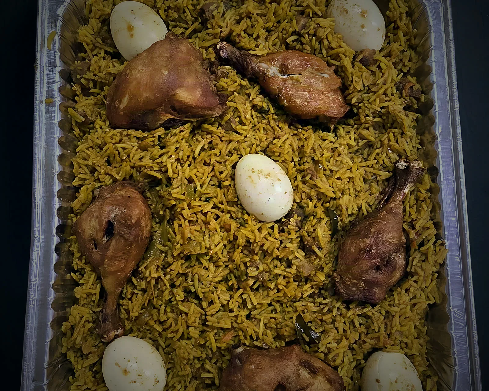 A full foil tray of Restaurant BMS chicken biryani with drumsticks and boiled eggs
